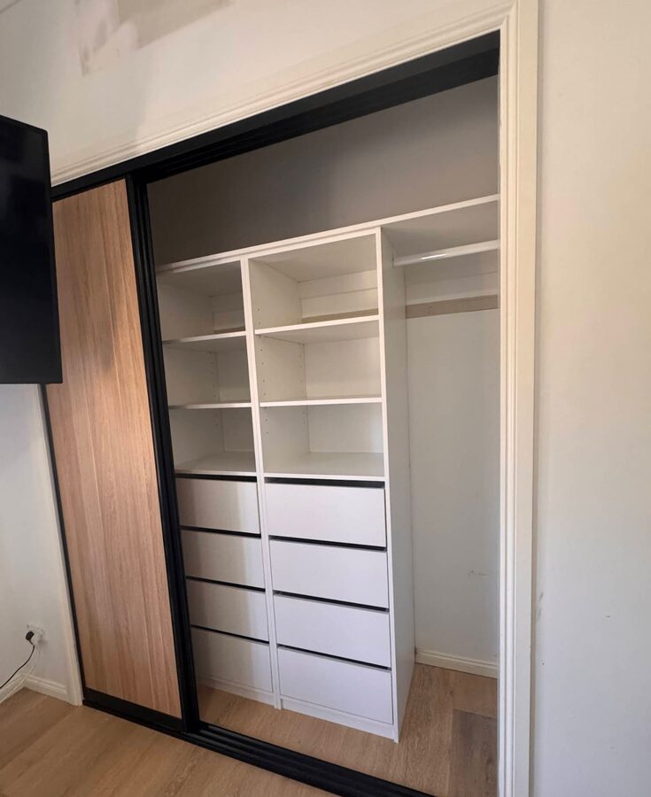 Sliding-door wardrobe with white internal shelving and drawers installed by Baldeco for Sam