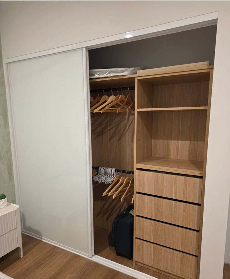Built-in wardrobe with sliding doors, timber shelving and drawers installed by Baldeco for Trish